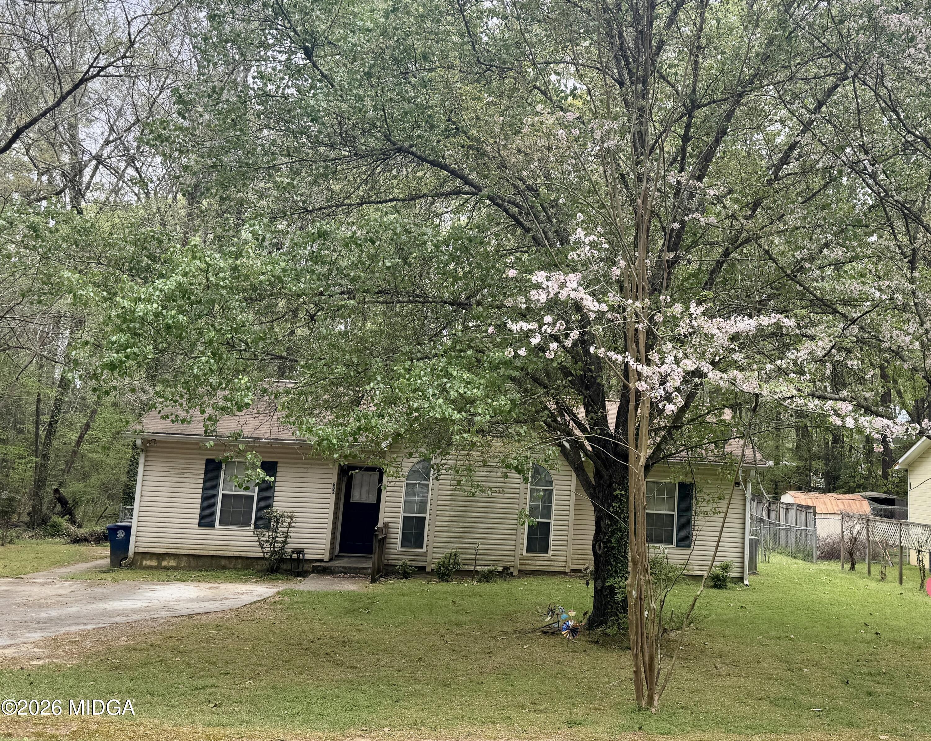 682 Wilderness Drive Macon, GA 31220 - Photo 17 of 25 a front view of a house with a garden and trees