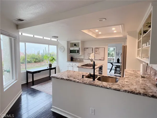 a kitchen with kitchen island granite countertop a large window and dining table
