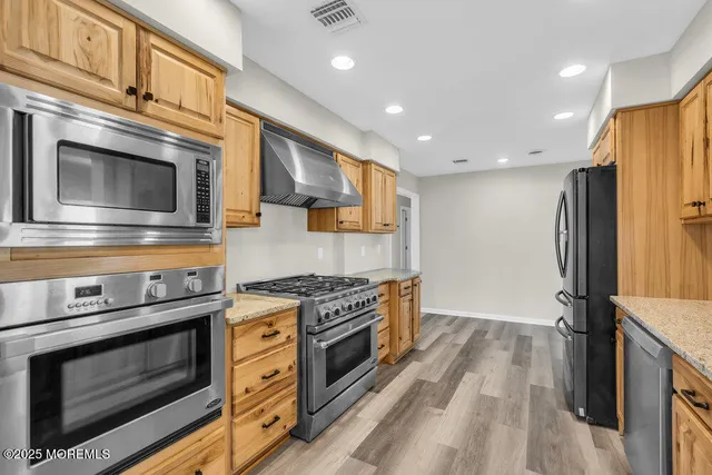 a kitchen with stainless steel appliances granite countertop a stove and a refrigerator