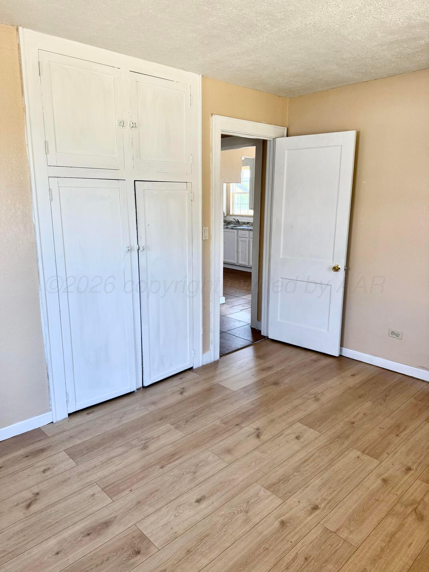 310 Coble Street Borger, TX 79007 - Photo 5 of 7 an empty room with wooden floor & closet area