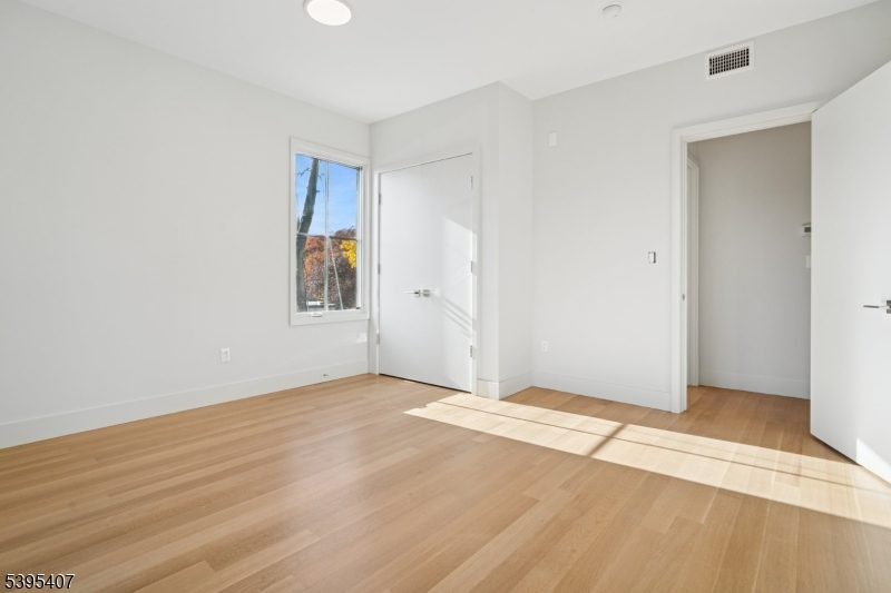75 Midland Avenue, Unit 2 Montclair, NJ 07042 - Photo 13 of 18 an empty room with wooden floor and windows