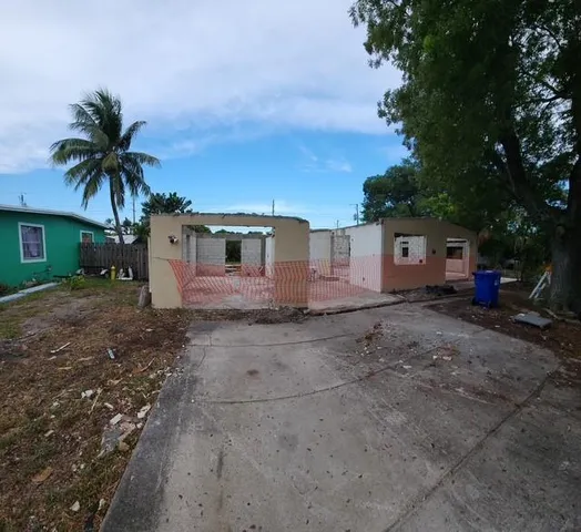 a view of a house with a backyard and a tree