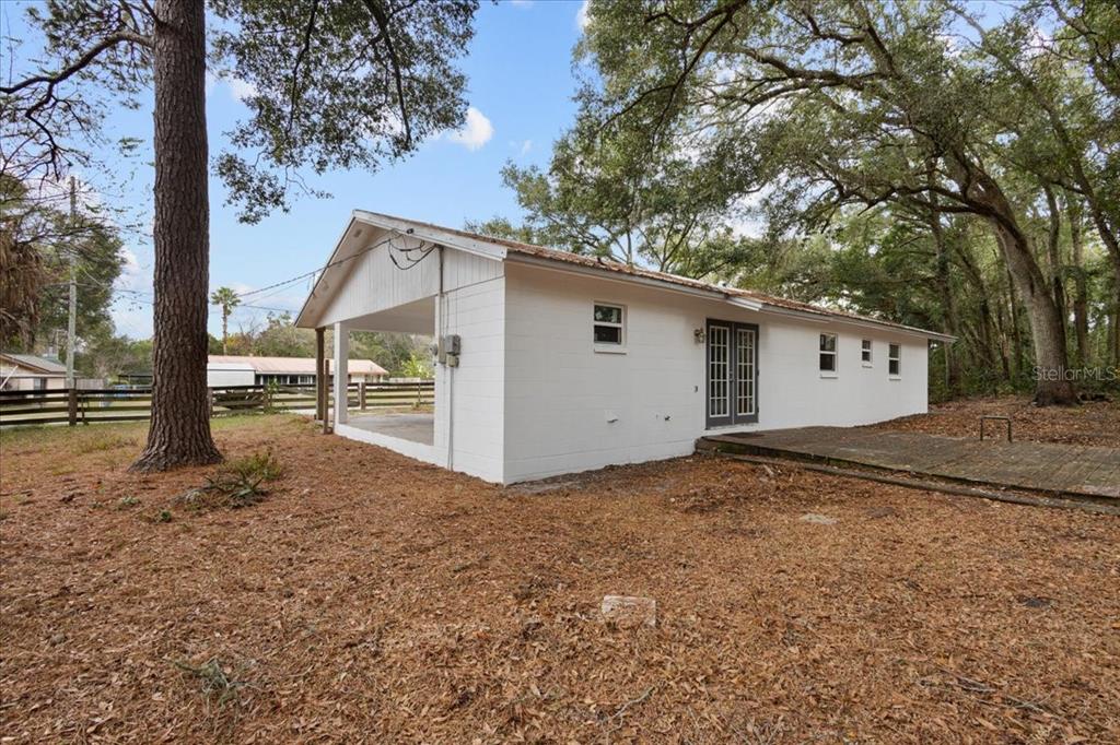 1315 Southwest 252nd Street Newberry, FL 32669 - Photo 25 of 29 a view of a house with a large tree and wooden fence