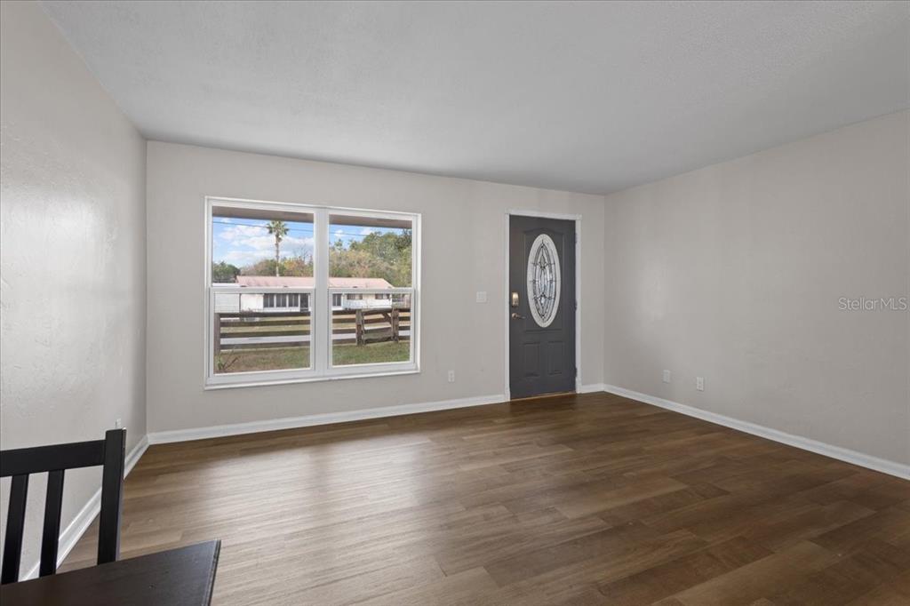 1315 Southwest 252nd Street Newberry, FL 32669 - Photo 7 of 29 a view of an empty room with a window and wooden floor