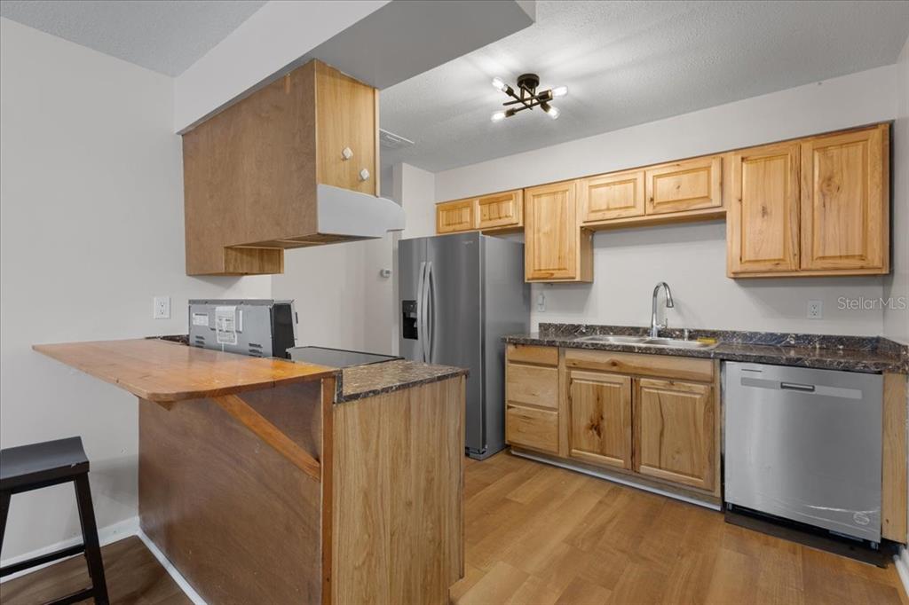 1315 Southwest 252nd Street Newberry, FL 32669 - Photo 8 of 29 a kitchen with granite countertop a sink stove and refrigerator