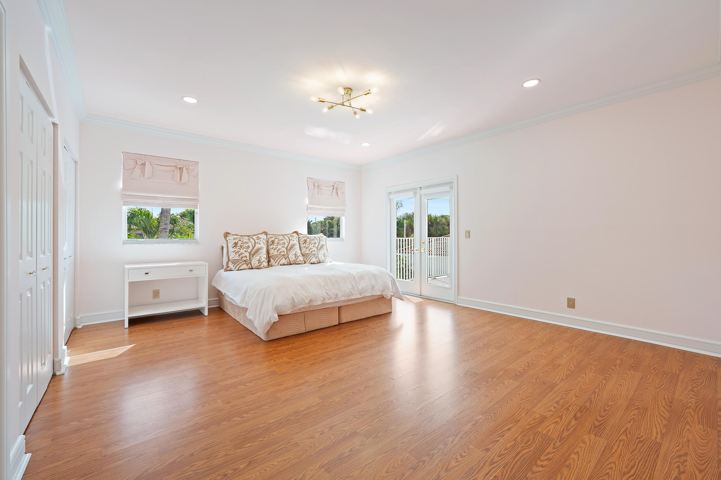 325 Eagle Drive Jupiter, FL 33477 - Photo 25 of 48 a bedroom with a large bed and a chandelier