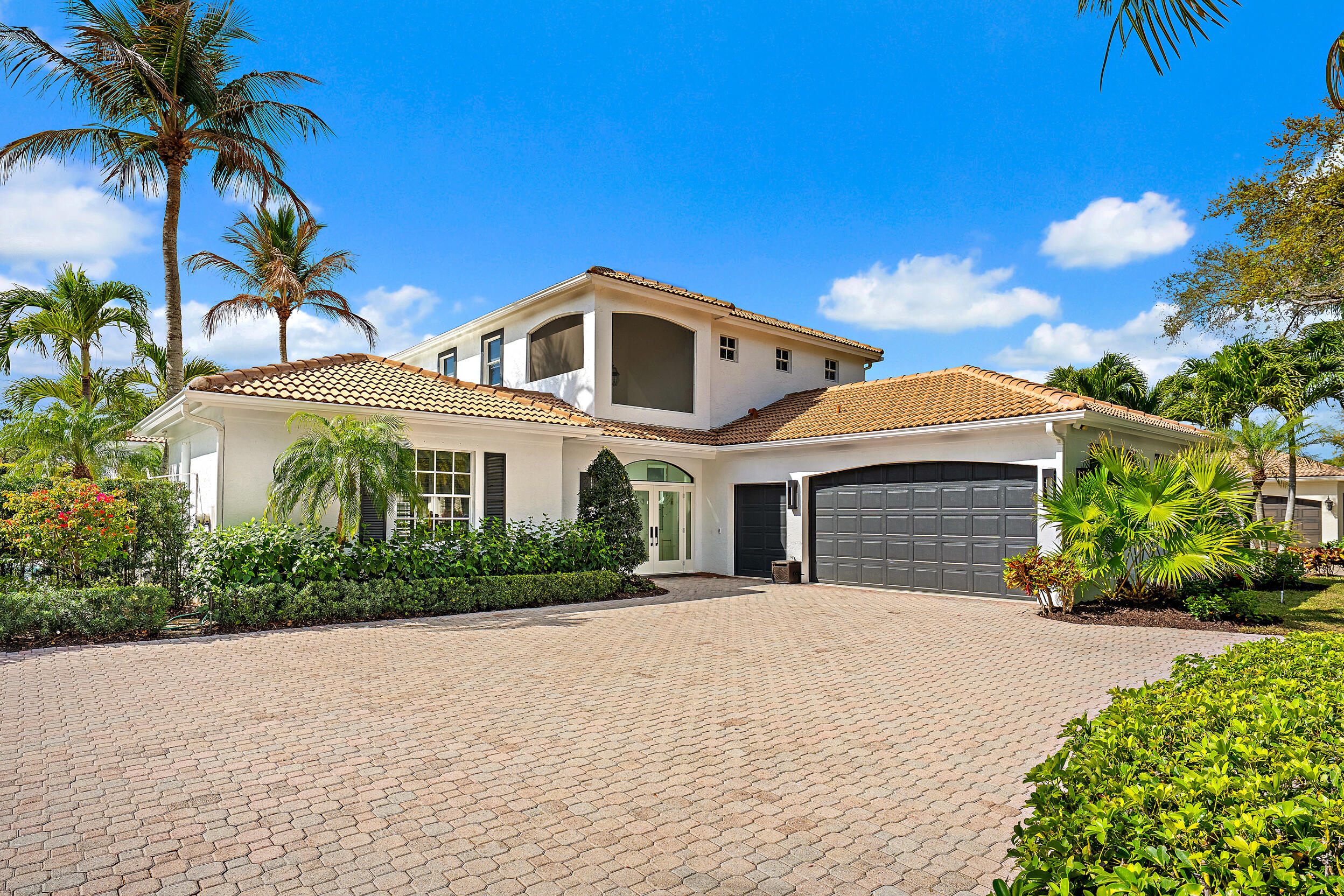 325 Eagle Drive Jupiter, FL 33477 - Photo 5 of 48 a front view of a house with a garden