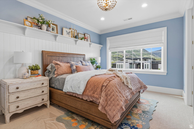 115 East Hidden Ridge Lane, Unit 42 Mapleton, UT 84664 - Photo 51 of 103 Spacious bedroom featuring light blue walls with white board and batten paneling, a large window with white trim, and a decorative ceiling light fixture
