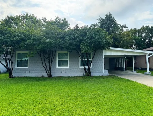 a view of a house with a yard and a large tree
