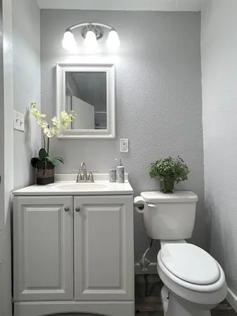 a bathroom with a toilet sink and mirror