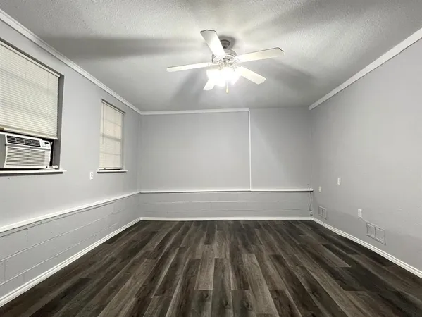 a view of a room with wooden floor and fan