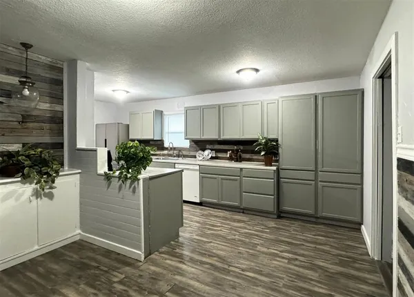 a kitchen with a refrigerator and a stove top oven