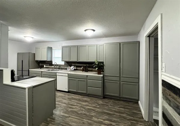 a kitchen with a refrigerator sink and cabinets