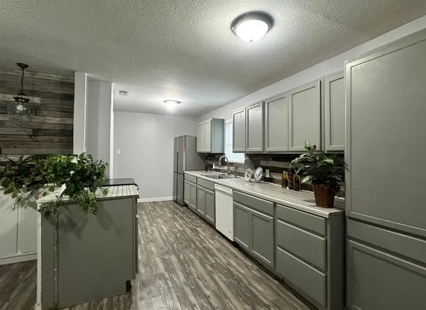 a kitchen with a sink stainless steel appliances and cabinets