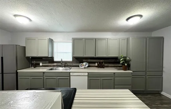 a kitchen with a sink a stove cabinets and refrigerator