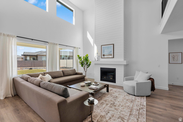 382 North Rhyolite Drive, Unit 111 Hurricane, UT 84737 - Photo 37 of 37 Two-story living area featuring wood-finish flooring, a contemporary fireplace with a shiplap surround, and high ceilings with upper transom windows