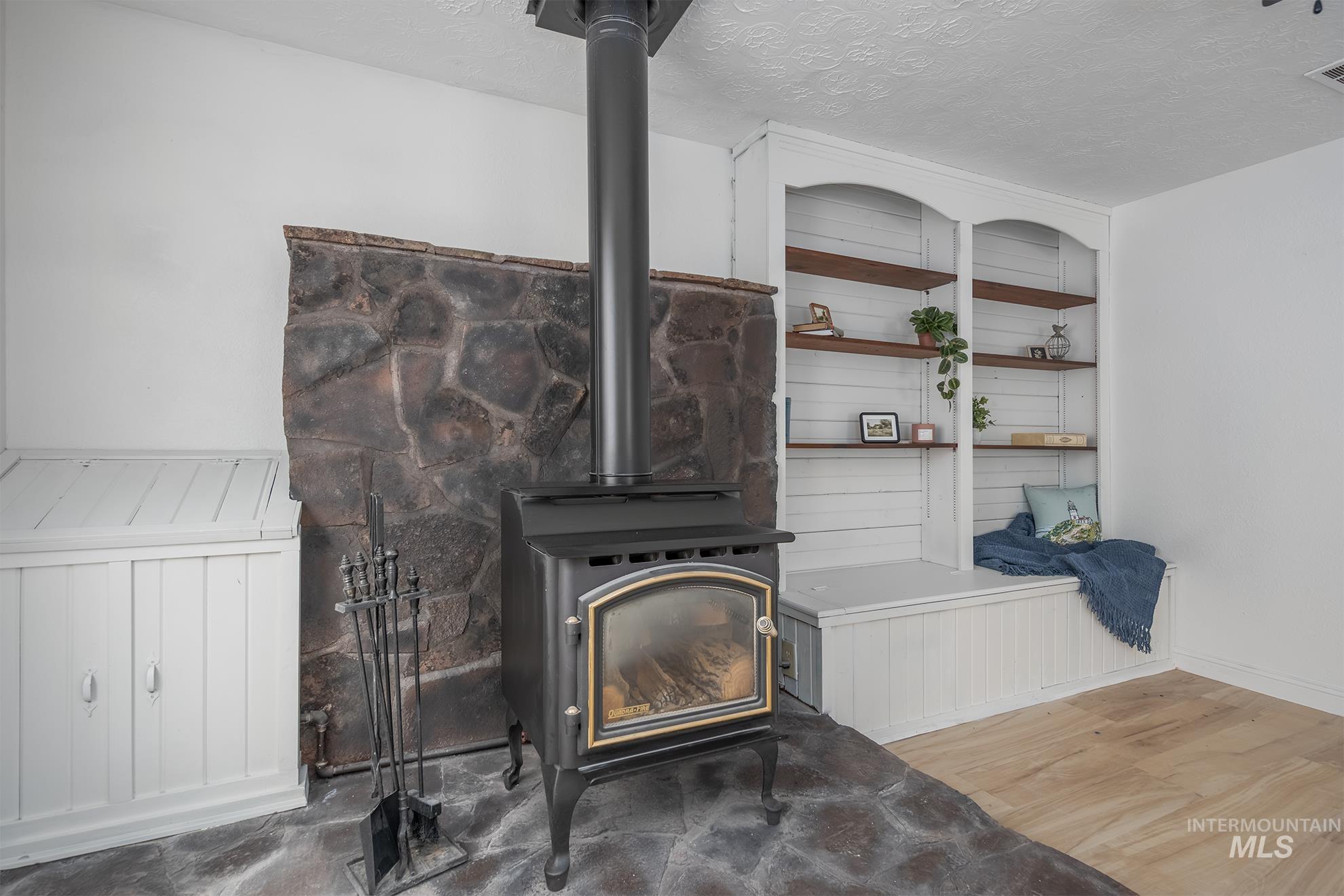 61 Southwest 4th Street Ontario, OR 97914 - Photo 19 of 42 Freestanding wood-burning stove with a stone hearth and wall surround