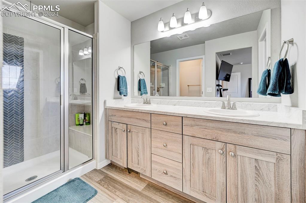 4472 Gneiss Loop Colorado Springs, CO 80938 - Photo 21 of 30 a bathroom with a double vanity sink and a mirror