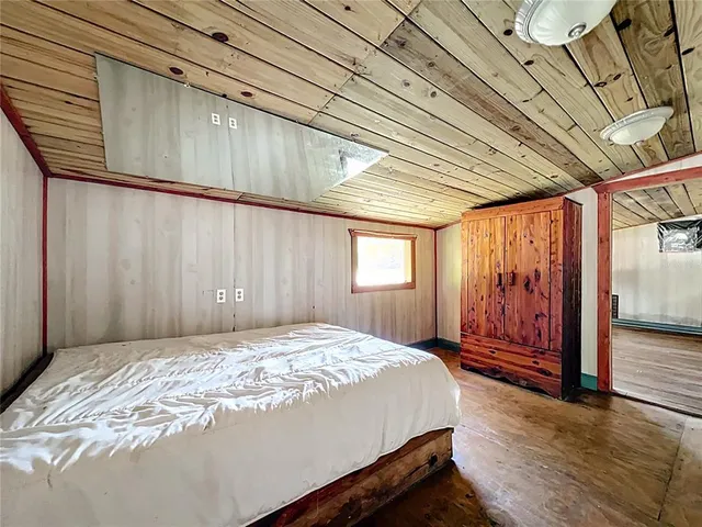 a bed sitting in a spacious bedroom next to a window