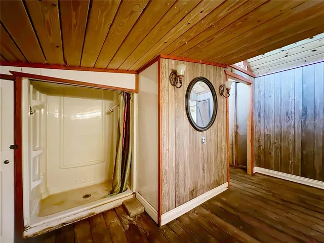 a bathroom with a mirror a shower and a sink