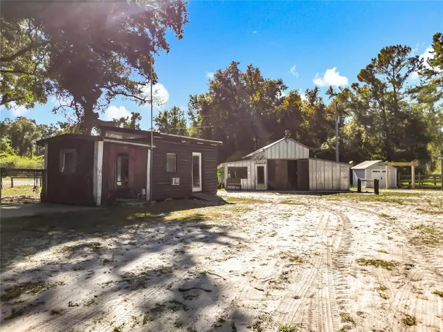 a wooden house with a large tree in front of it