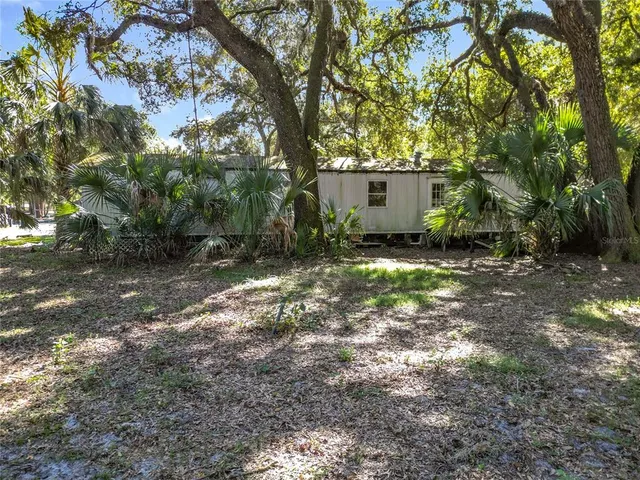 a view of a house with large trees