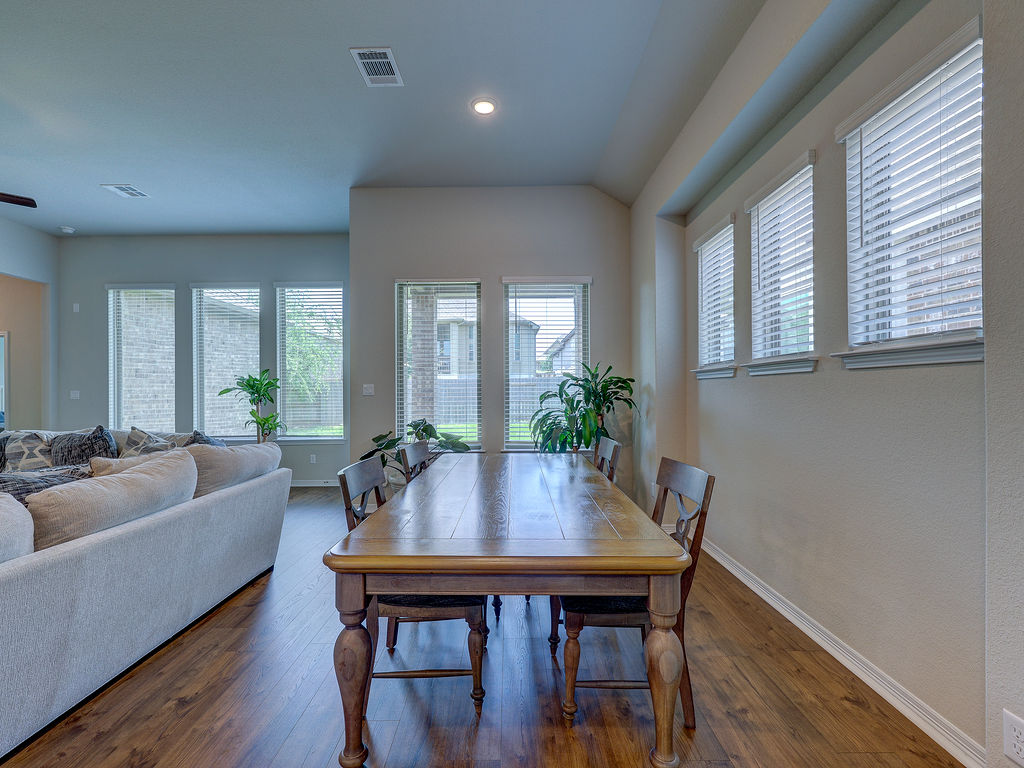 229 Heartleaf Road San Marcos, TX 78666 - Photo 17 of 40 Natural light bathes this spacious dining area with handsome wood flooring, flowing into an inviting living space.
