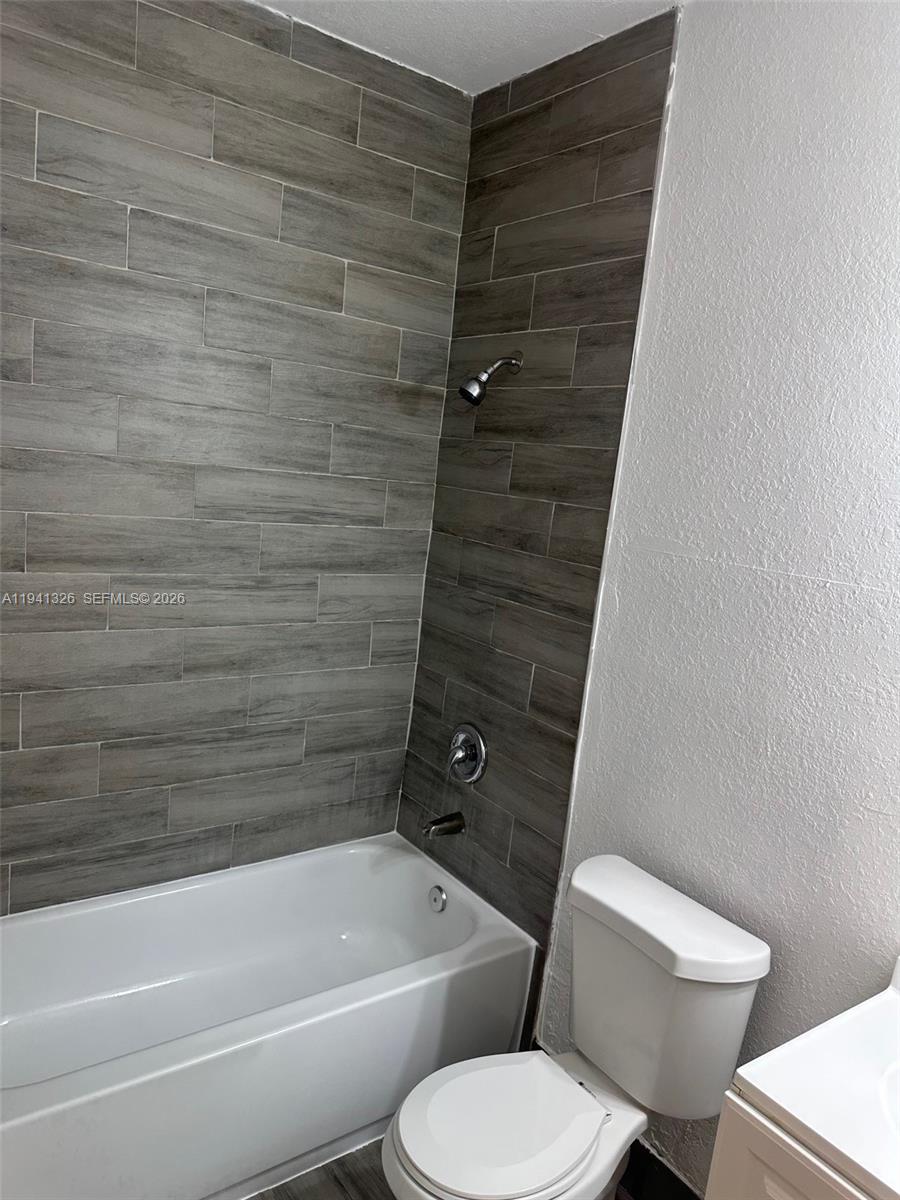 1663 Southeast 27th Drive, Unit 102 Homestead, FL 33035 - Photo 13 of 18 a bathroom with a toilet and a bath tub