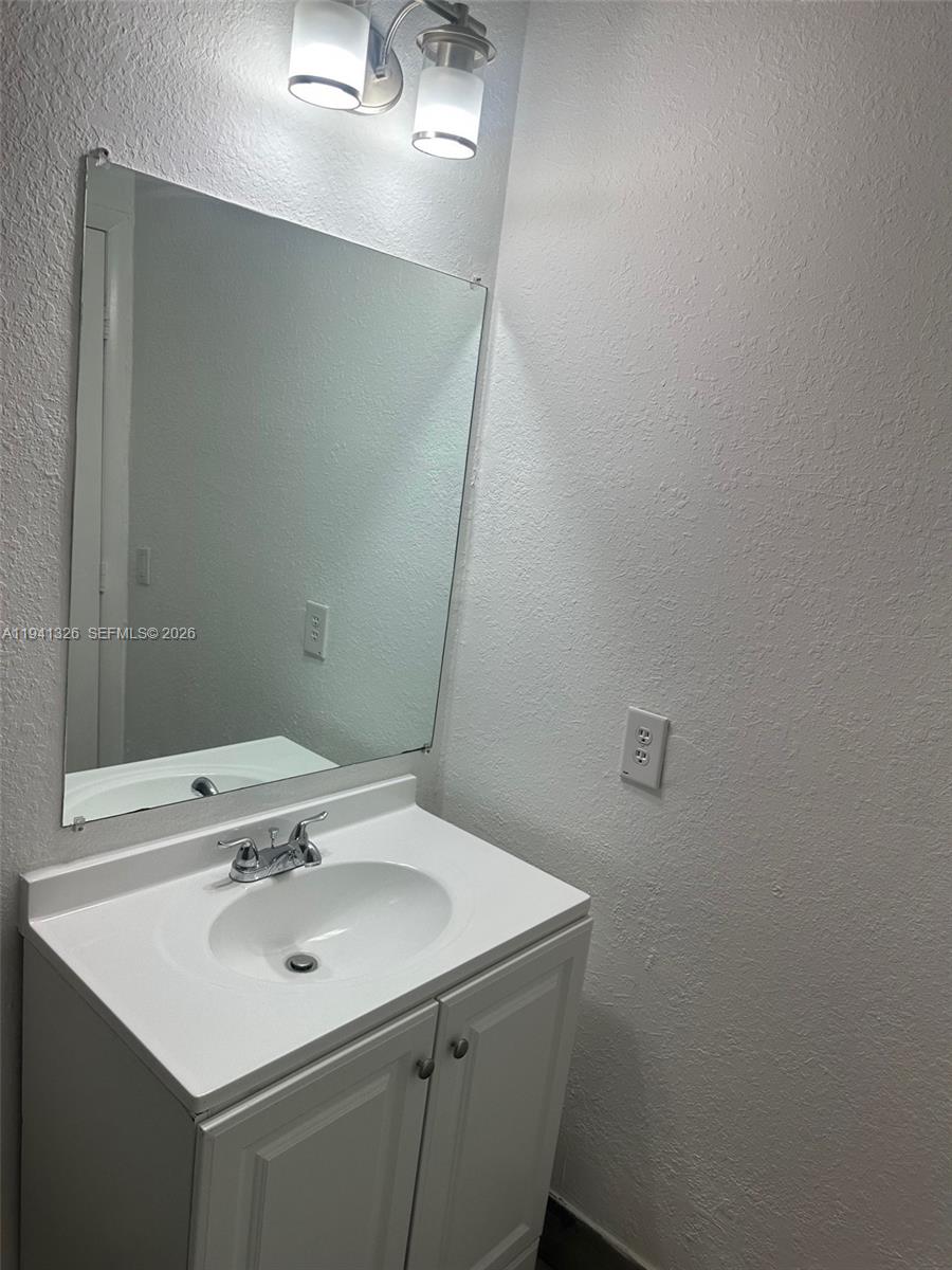 1663 Southeast 27th Drive, Unit 102 Homestead, FL 33035 - Photo 14 of 18 a bathroom with a sink and a mirror