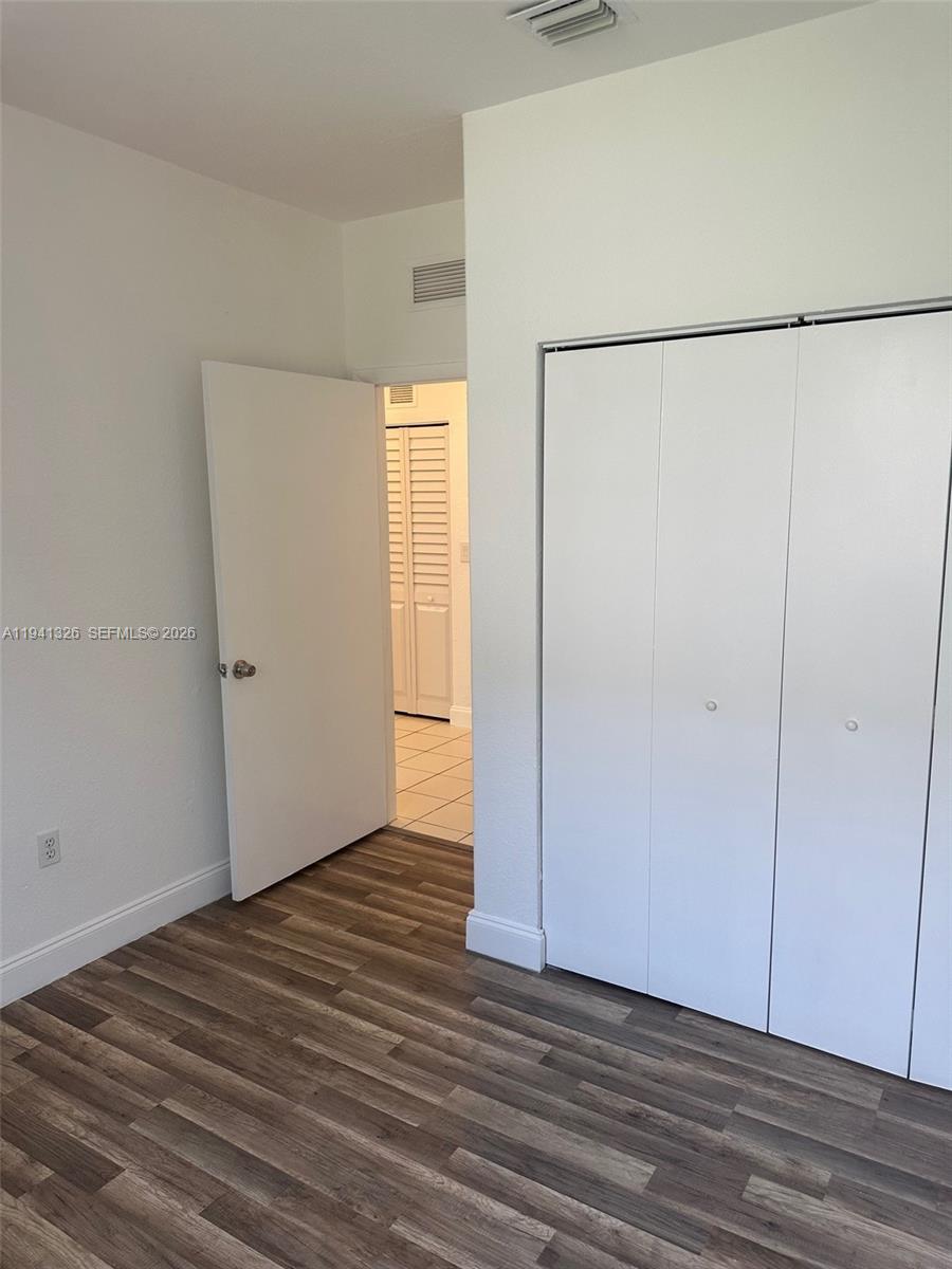 1663 Southeast 27th Drive, Unit 102 Homestead, FL 33035 - Photo 16 of 18 a view of an empty room with wooden floor