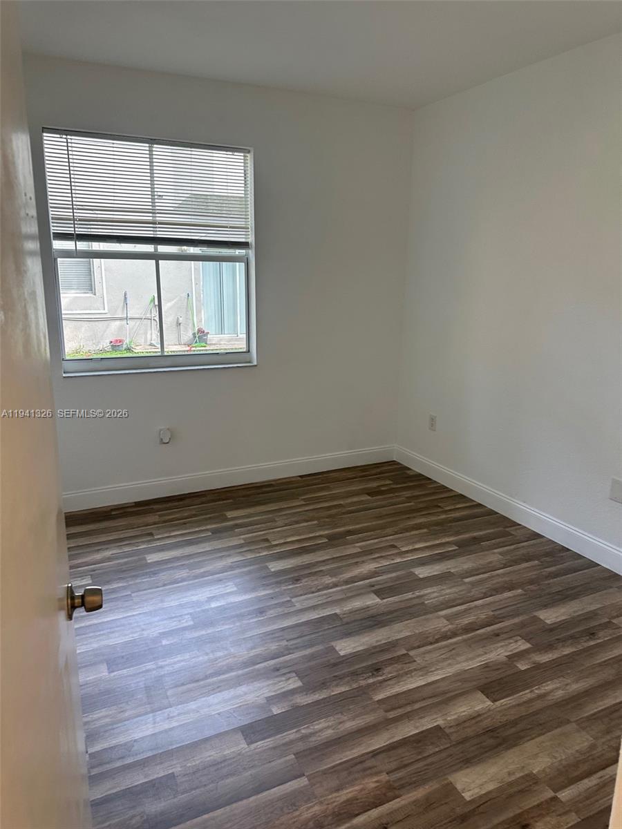1663 Southeast 27th Drive, Unit 102 Homestead, FL 33035 - Photo 17 of 18 a view of a room with wooden floor and window