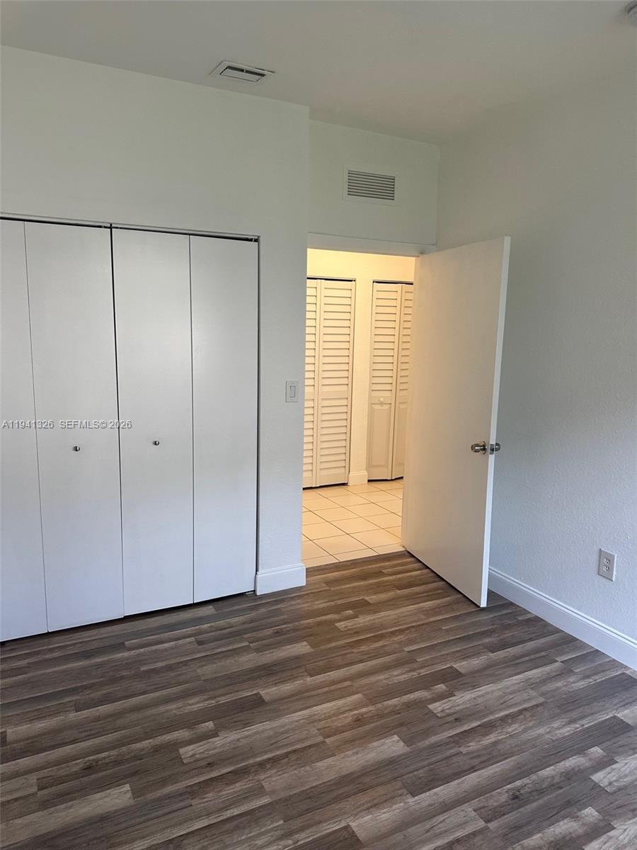 1663 Southeast 27th Drive, Unit 102 Homestead, FL 33035 - Photo 18 of 18 a view of an empty room with wooden floor