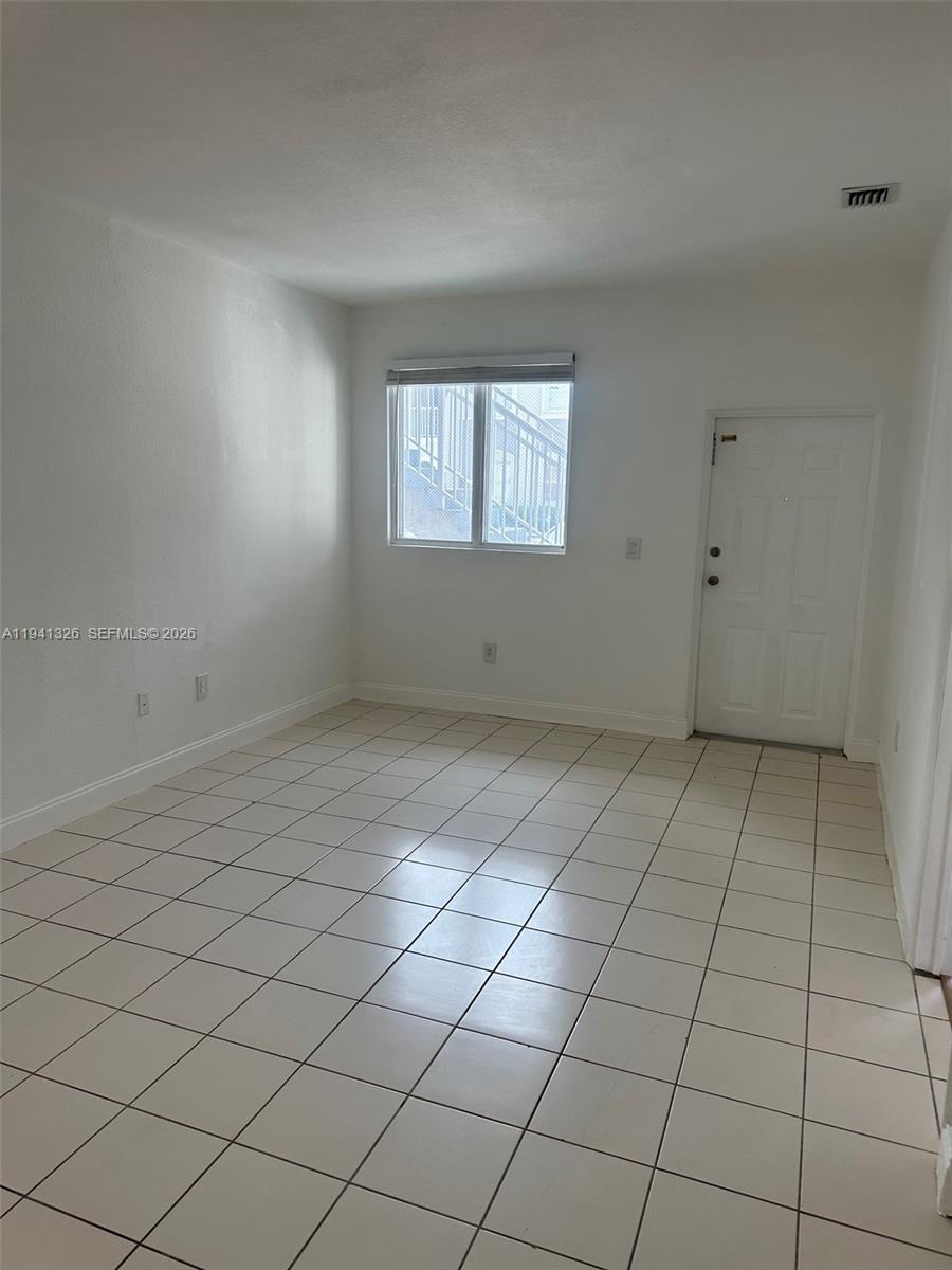 1663 Southeast 27th Drive, Unit 102 Homestead, FL 33035 - Photo 3 of 18 an empty room with windows