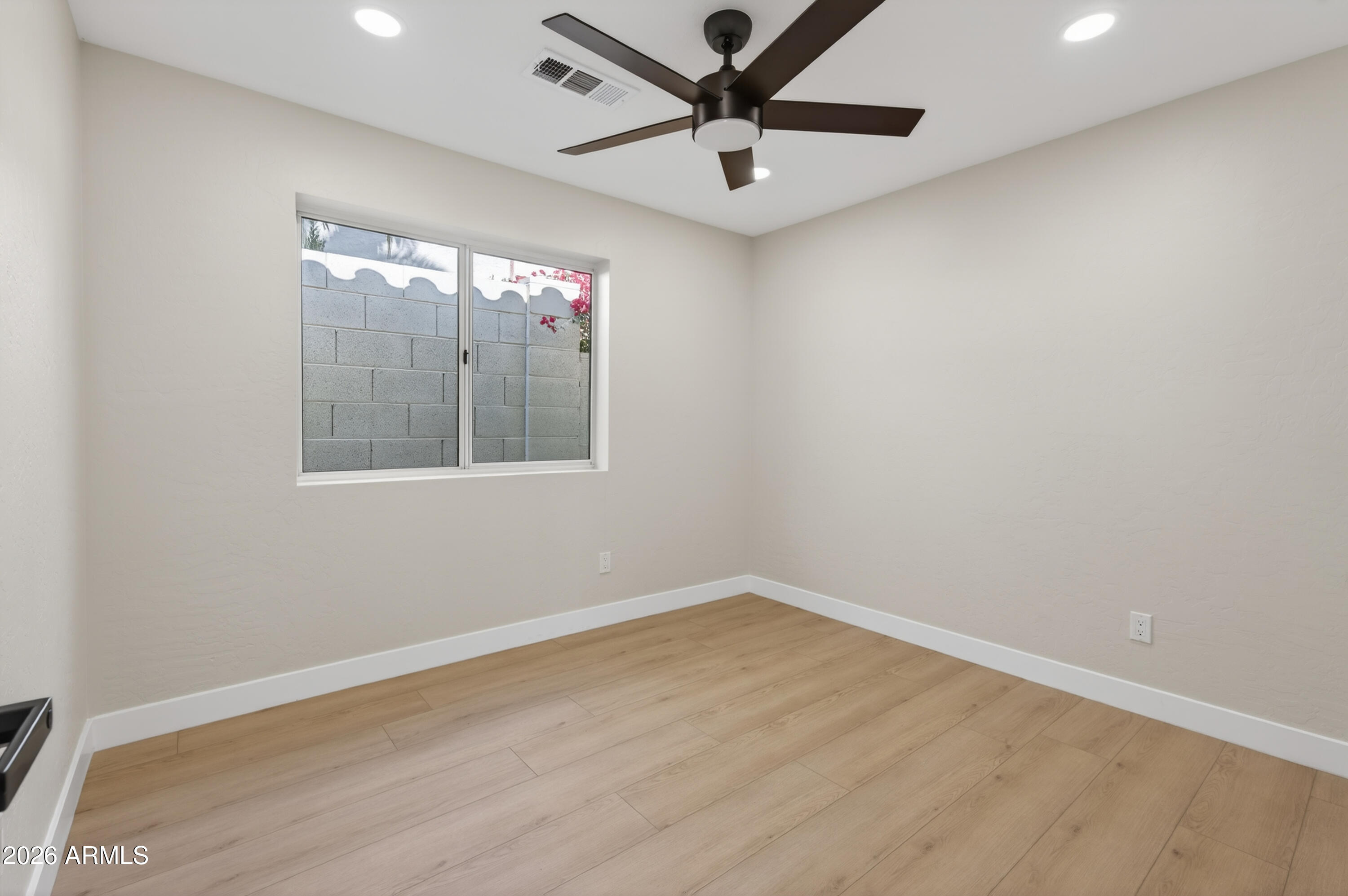 4814 East Monte Way Phoenix, AZ 85044 - Photo 22 of 42 an empty room with wooden floor and windows
