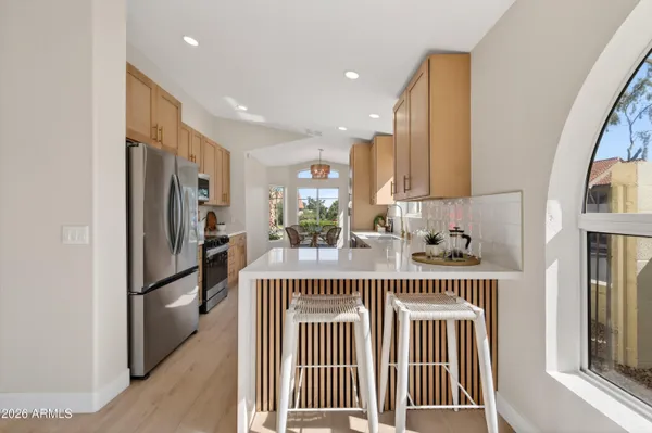 a kitchen with stainless steel appliances granite countertop a refrigerator a sink and a stove