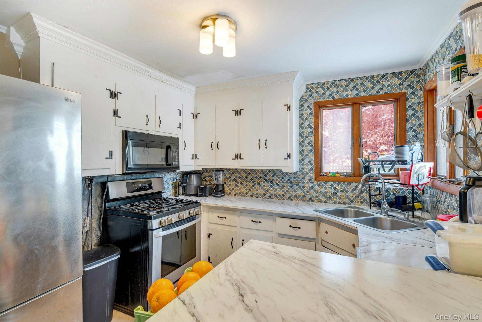 32 Stackyard Drive Mastic Beach, NY 11951 - Photo 9 of 25 a kitchen with granite countertop a stove a sink and a refrigerator