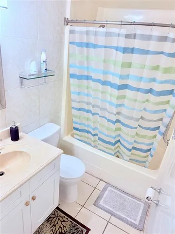 a bathroom with a sink a toilet and shower curtain