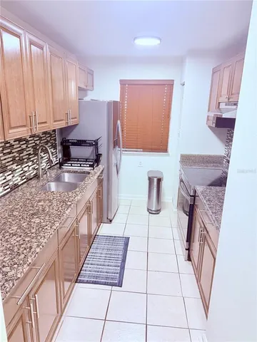 a kitchen with stainless steel appliances granite countertop a stove a sink and a microwave