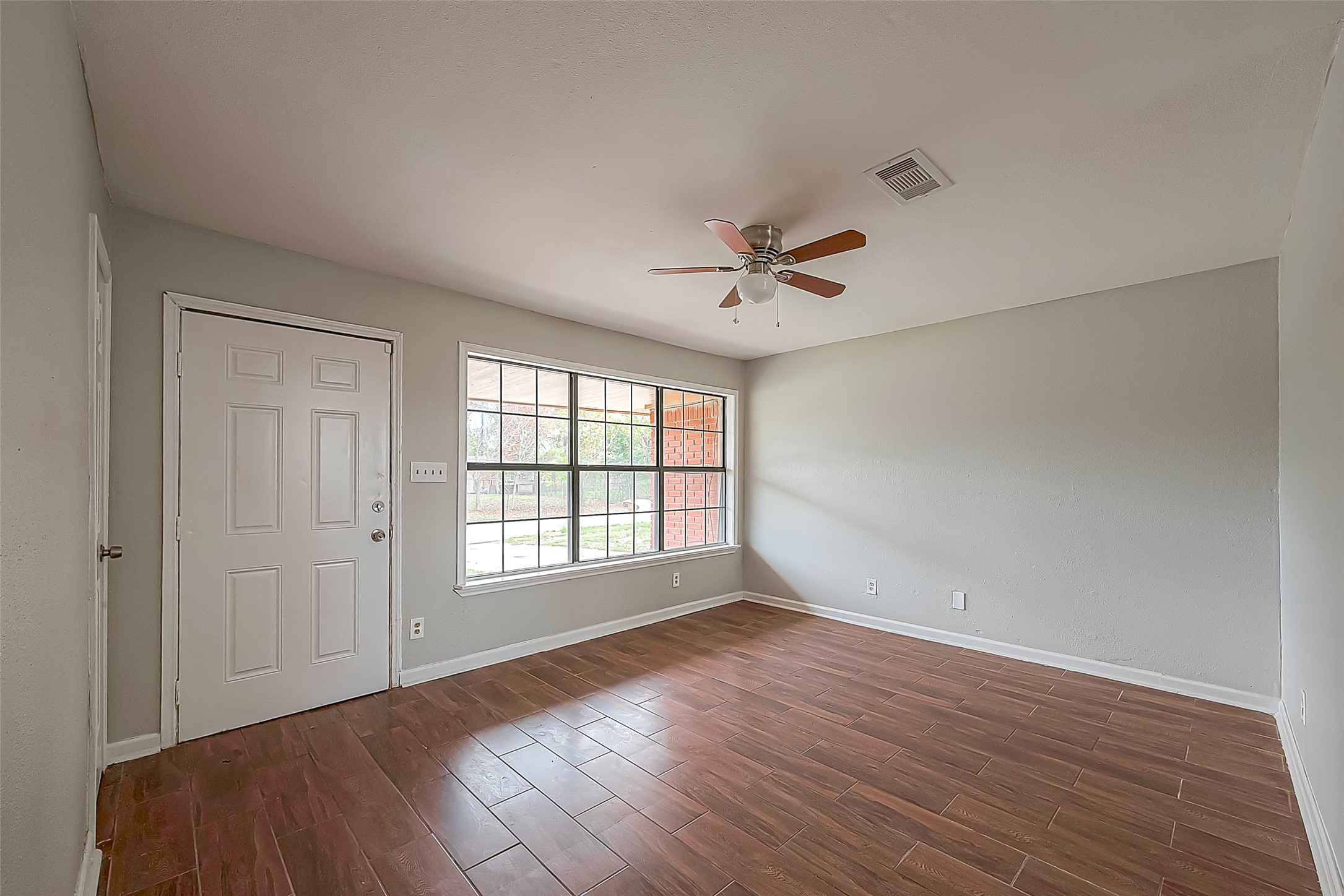 11615 Duane Street Houston, TX 77047 - Photo 2 of 14 a view of an empty room with a window and wooden floor