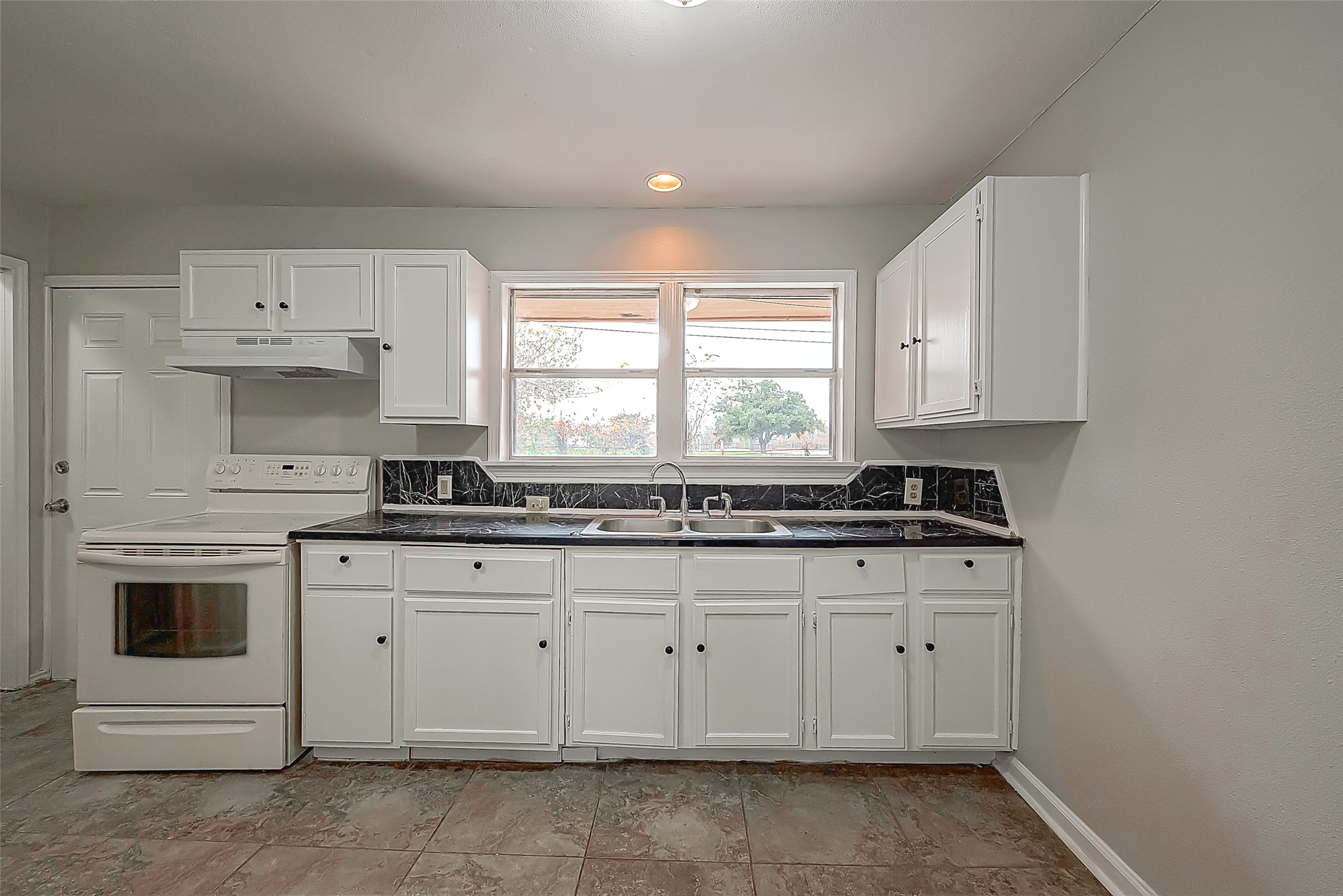 11615 Duane Street Houston, TX 77047 - Photo 3 of 14 a kitchen with granite countertop white cabinets and white appliances