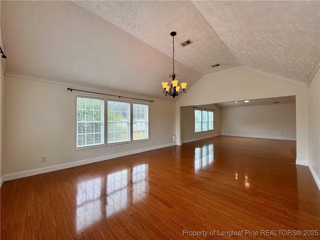 a view of an entryway wooden floor and a chandelier
