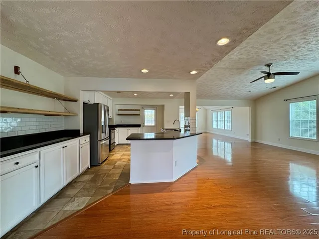a large kitchen with stainless steel appliances granite countertop a large counter top and a stove