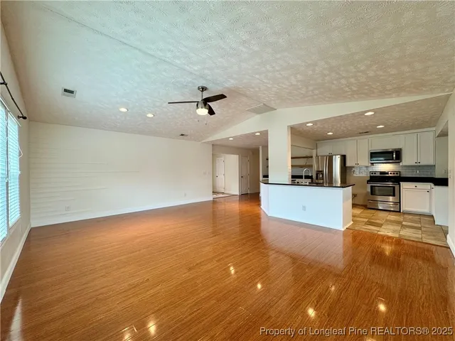 a view of kitchen and hall with wooden floor