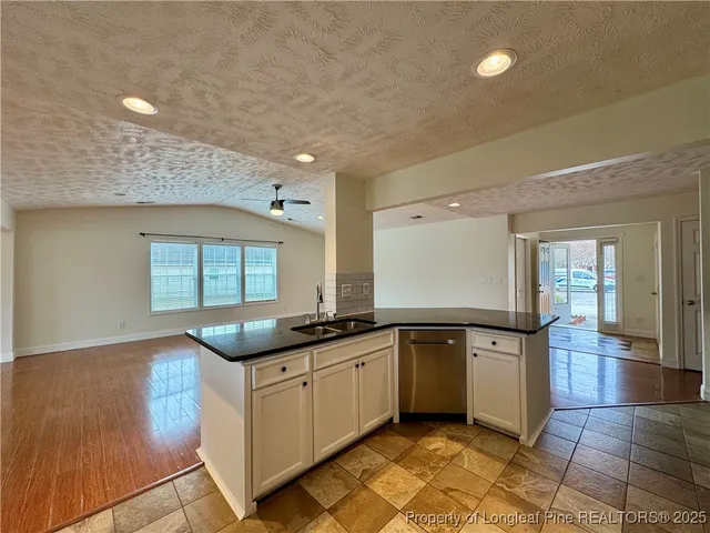 a kitchen with granite countertop a sink and cabinets