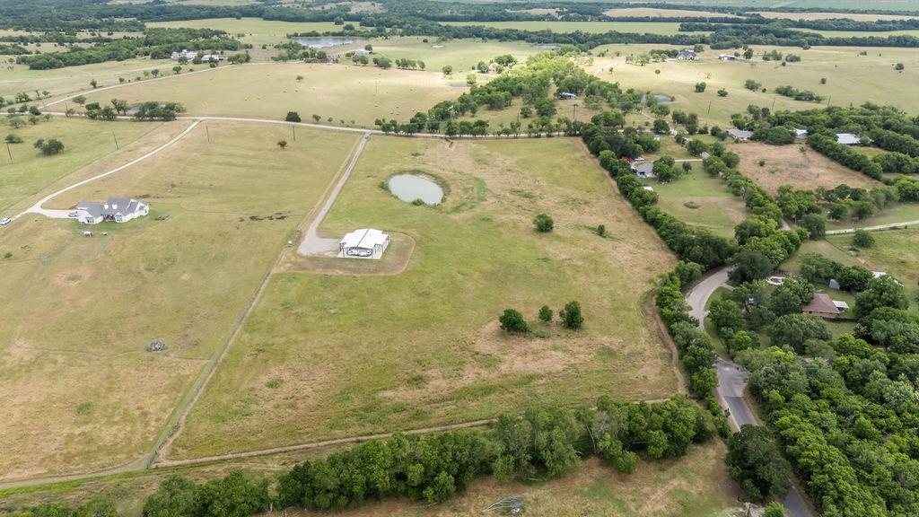1161 Alsdorf Road Ennis, TX 75119 - Photo 8 of 28 Expansive property featuring a private pond, long paved driveway, and mature landscaping