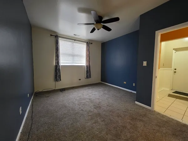 a view of a livingroom with a ceiling fan and window