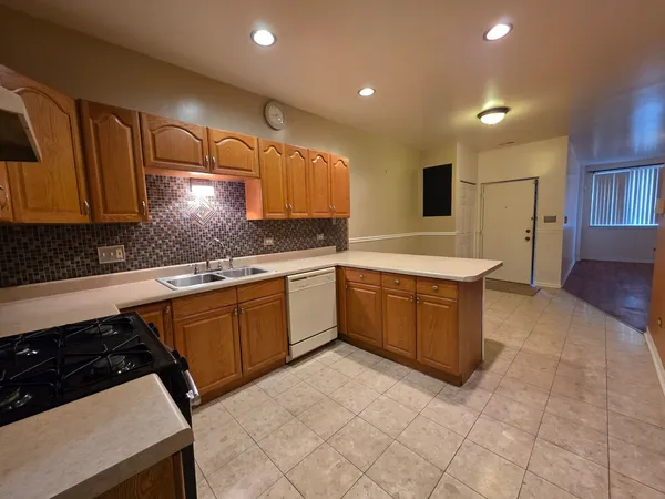 a large kitchen with stainless steel appliances a sink a stove a microwave a counter top space and cabinets
