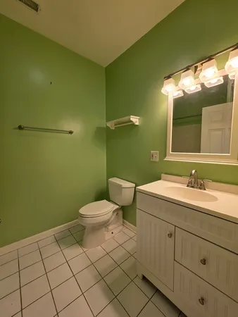 a bathroom with a toilet a sink and mirror