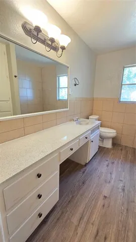 a bathroom with a double vanity sink mirror and toilet