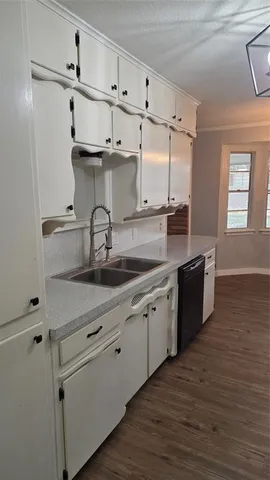 a kitchen with granite countertop white cabinets and white appliances